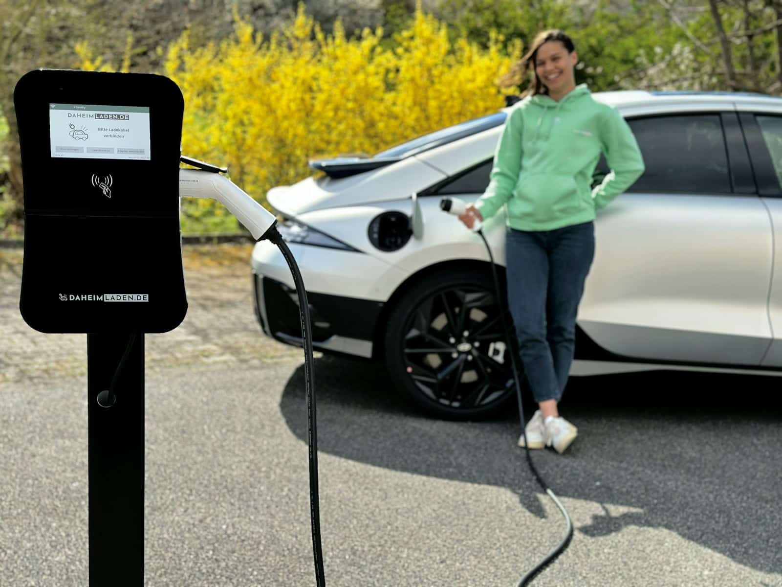 Une jeune femme recharge sa voiture électrique